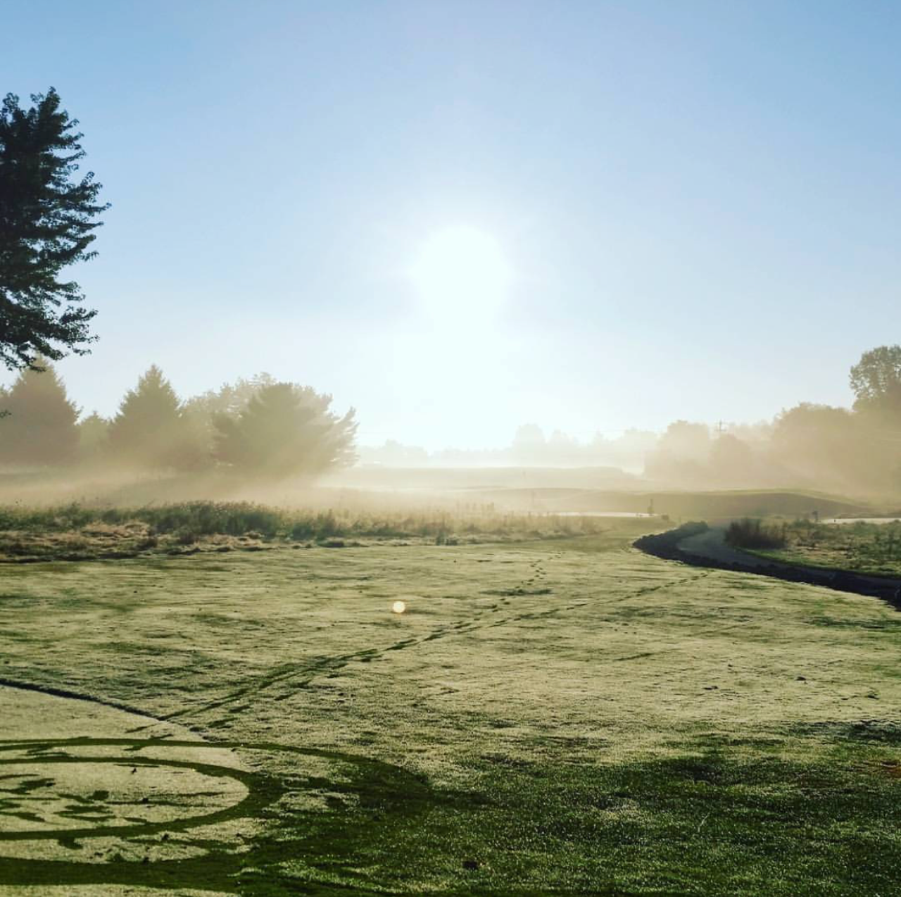 Golf course with sun in the sky